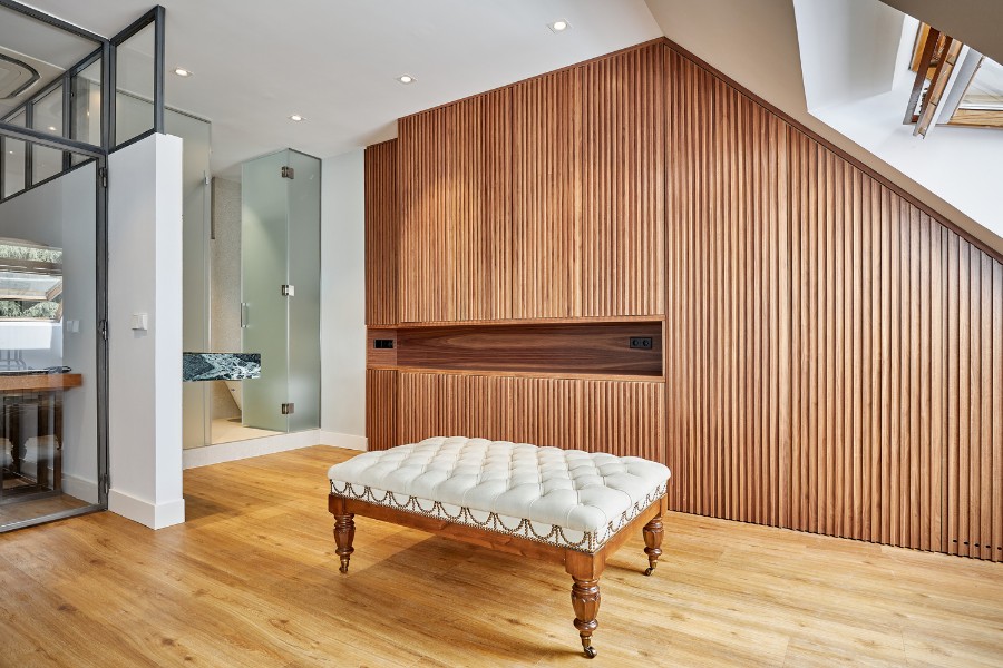 interior de buhardilla reformada con panelado de madera y suelo de tarima en Madrid